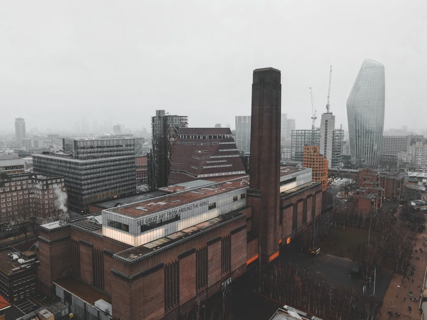 A wide-angle aerial view of the Tate Modern area in Bankside, London, taken from a high vantage point. The image shows the River Thames with several boats moving across its surface. On the near side, 